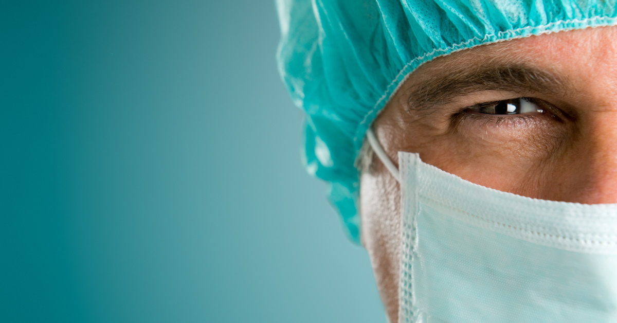Mature male surgeon gazing and looking at camera at hospital, close up shot