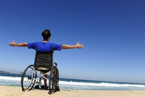 insurance: man in wheelchair enjoying the  beach