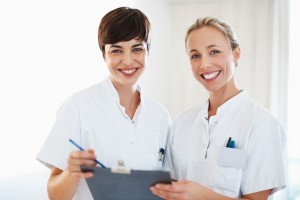 Portrait of female healthcare professionals smiling and discussing medical report