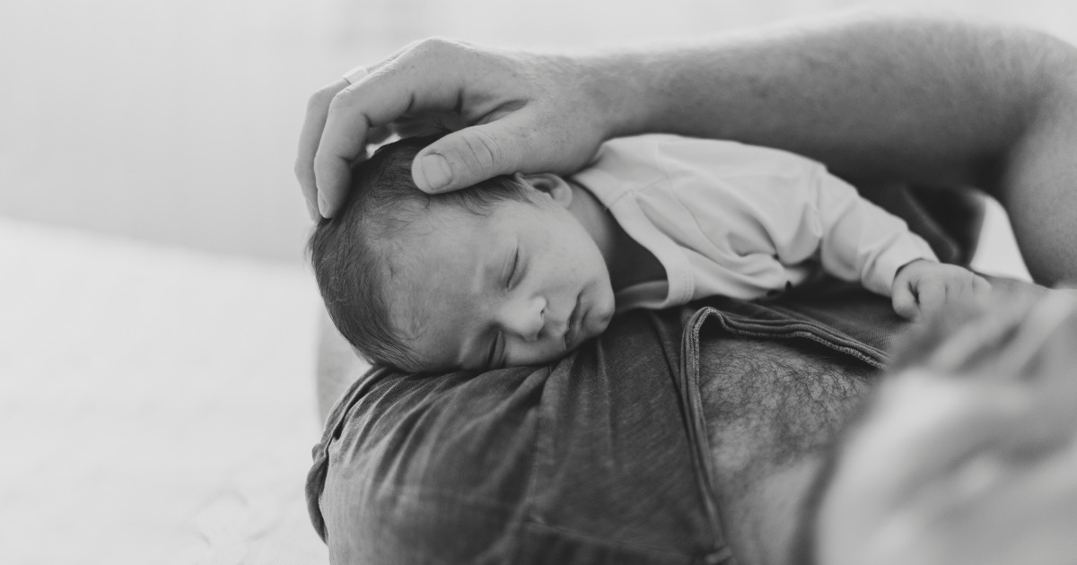 primer-padre-sosteniendo-sueno-bebe-escala-grises